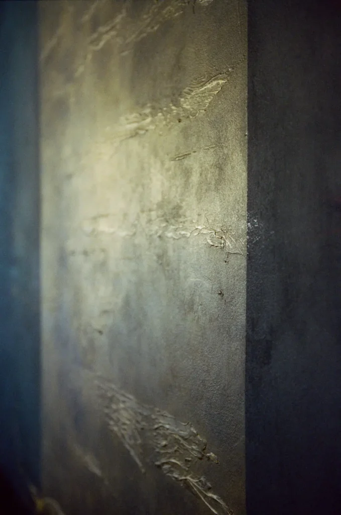 Navy and gold hand-finished plaster on the sapphire wall in the lounge, close