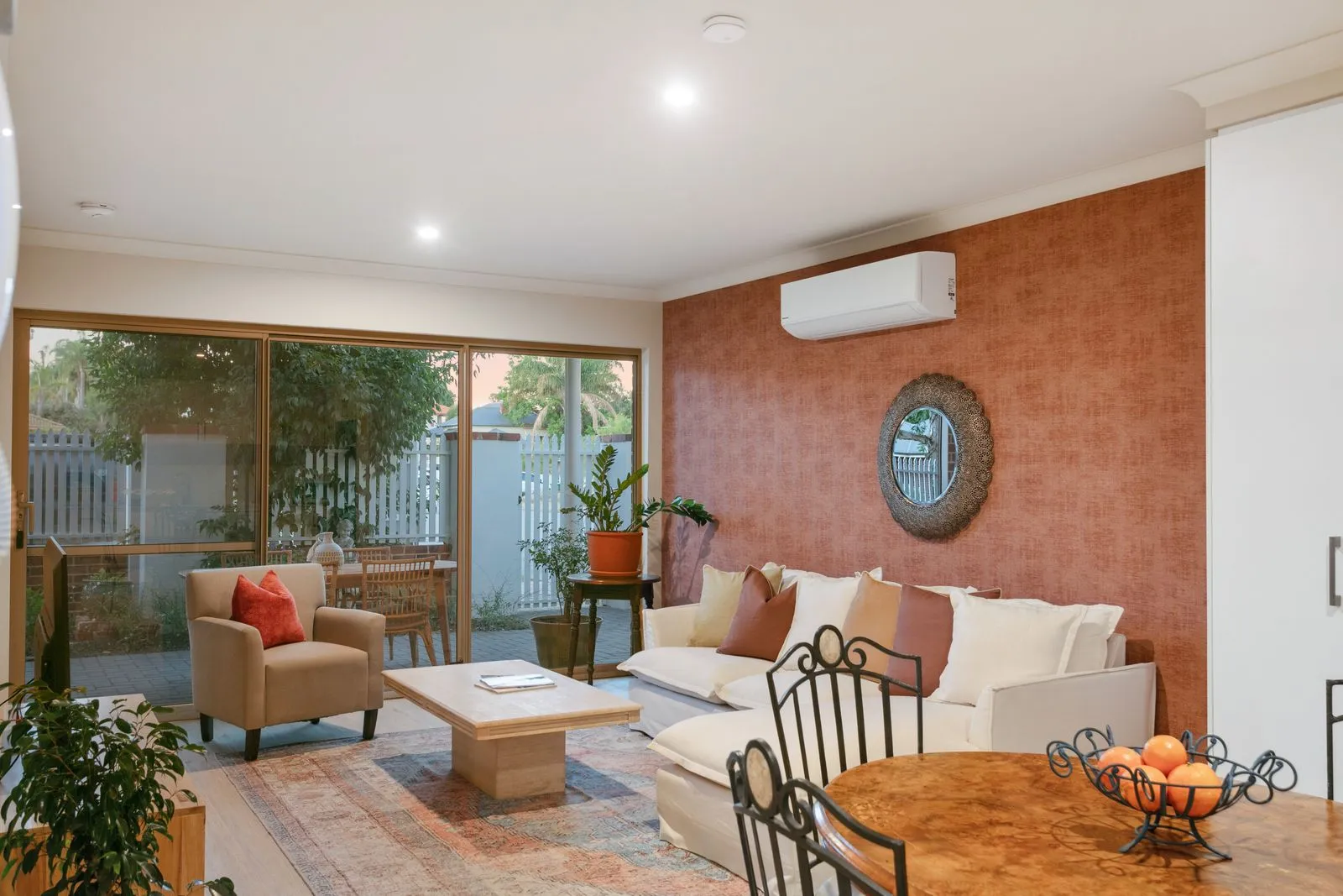 The living room at Terra de Sol, terracotta wall and glass doors open to the courtyard