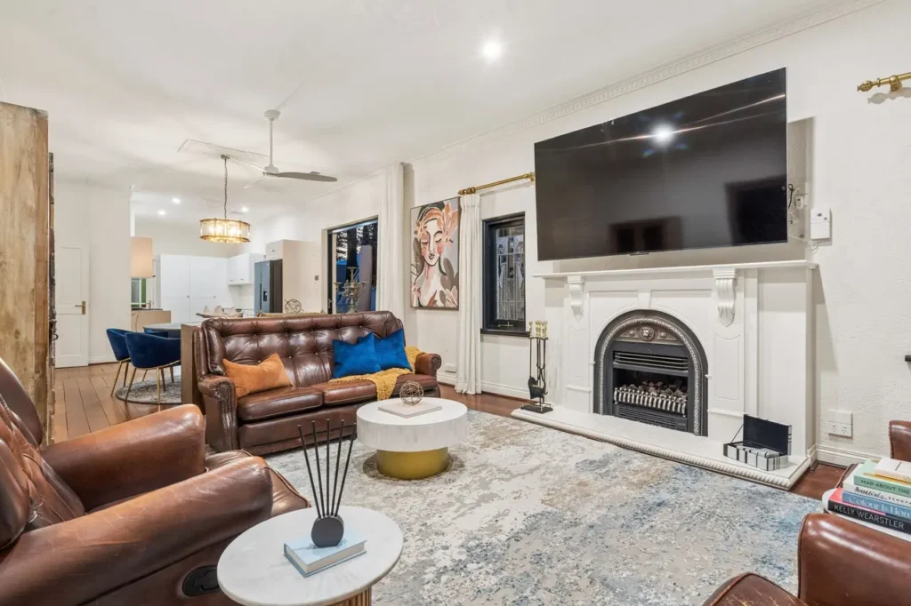 Leather chesterfields in the shared lounge with the marble fireplace beyond