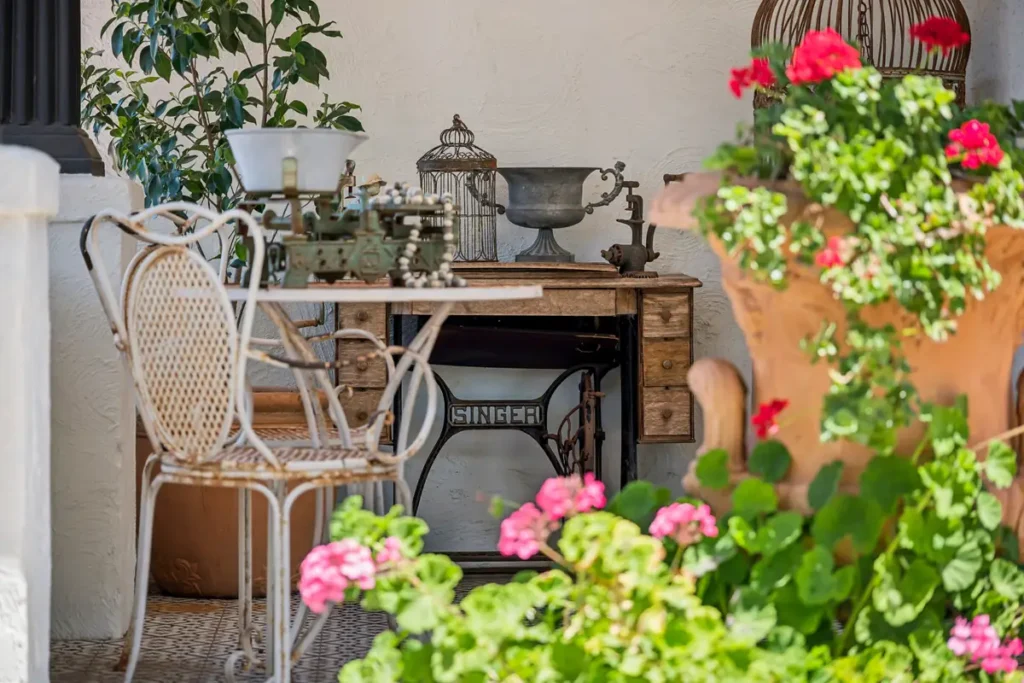 Geraniums, a cane chair and an old Singer table on the verandah
