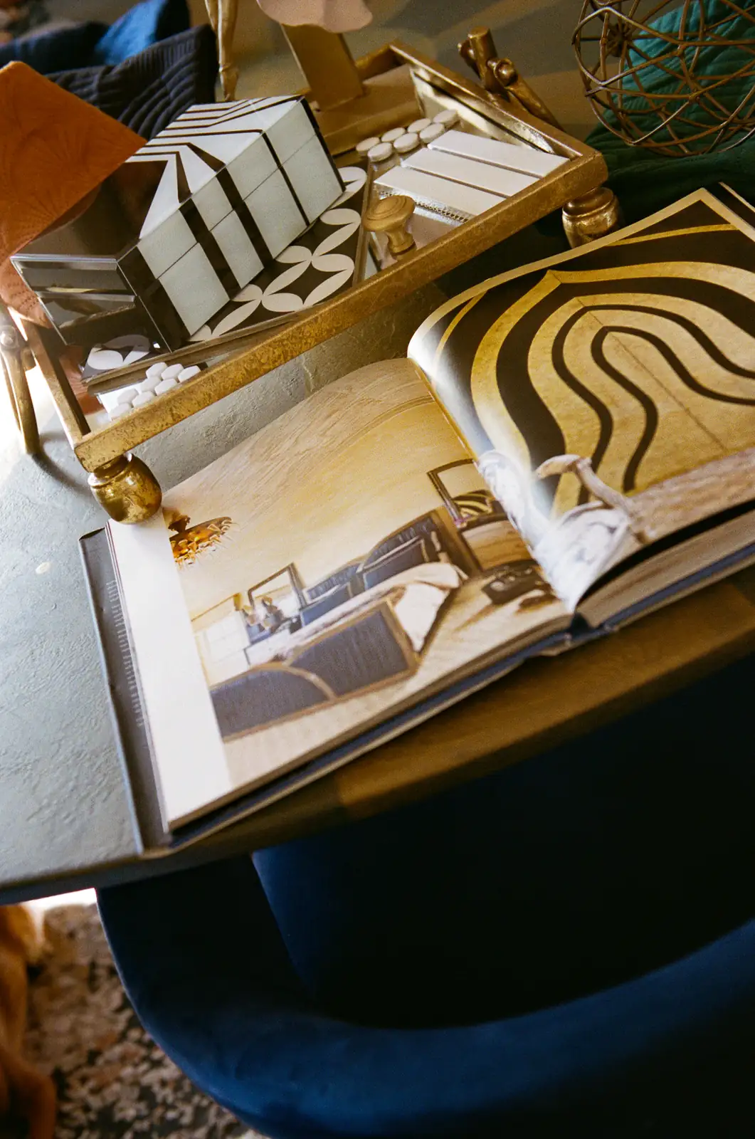 Tile and finish samples laid out on a tray beside an open interiors book
