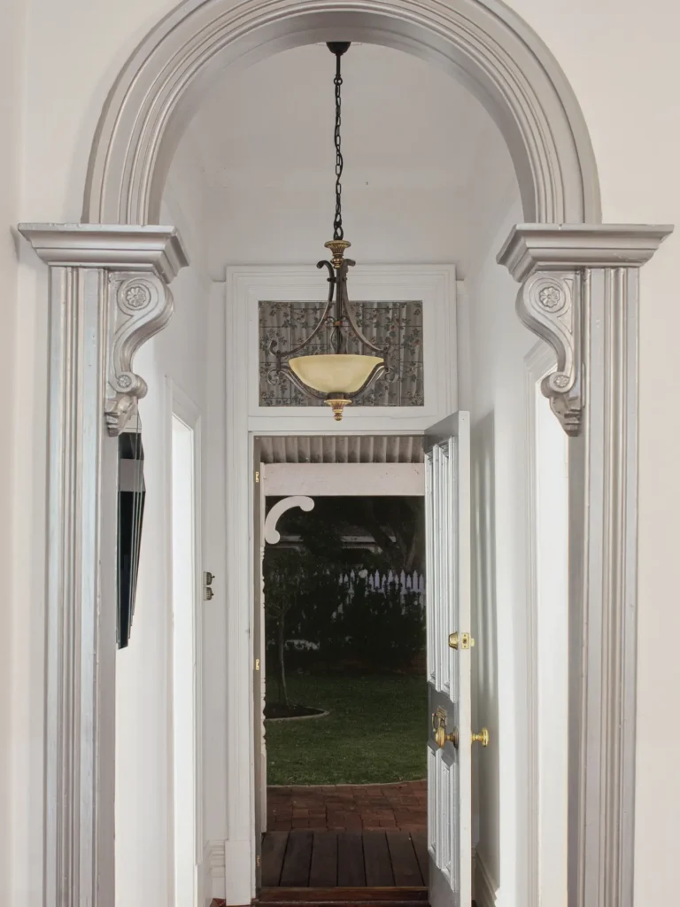 An arched hall with carved corbels looking through to the garden