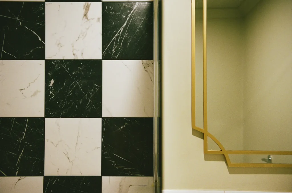 Checkerboard marble tile and a gold-framed mirror