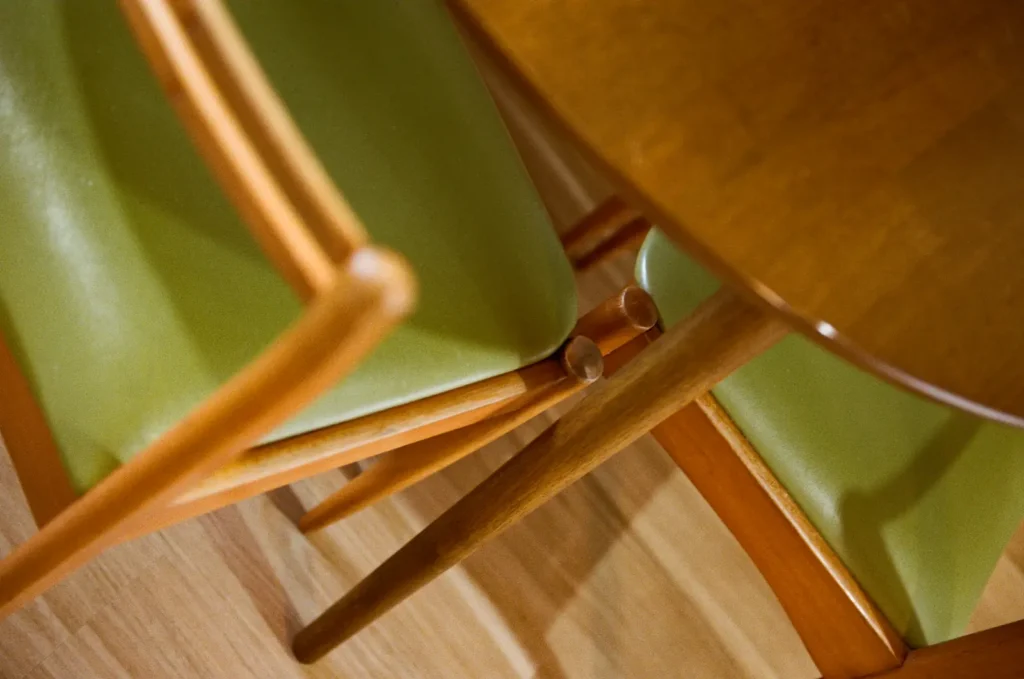 A green vinyl and timber dining chair, close