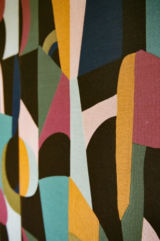 Abstract geometric fabric in teal, mustard, rose and black